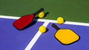 pickleball-set-of-two-paddles-and-two-balls-laid-out-on-a-pickleball-court (1)